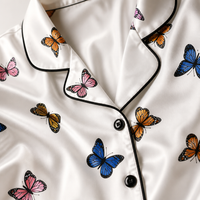 Close-up of the satin butterfly print, notch collar and black contrast piping