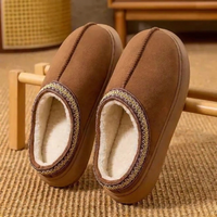 Chestnut fleece-lined slip-on slippers with braided collar, resting on a wooden rail